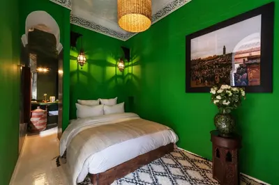 a green bedroom with a bed and a green wall at Riad Les Yeux Bleus in Marrakech