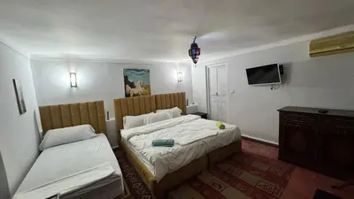 a bedroom with a bed and a desk and a tv at Dar el Koutoubia in Marrakech
