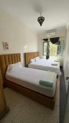 a bedroom with two beds and a window at Dar el Koutoubia in Marrakech