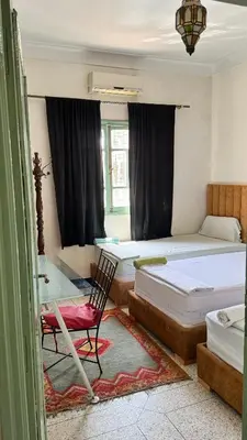 a bedroom with two beds and a desk and a chair at Dar el Koutoubia in Marrakech
