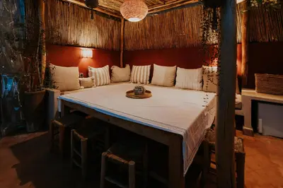 a large bed in a room with stools at Riad Nanou - Private Riad with Pool & Rooftop in Marrakech