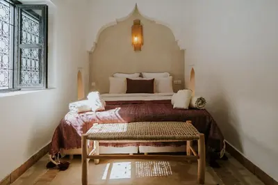 a bedroom with a bed and a table in it at Riad Nanou - Private Riad with Pool & Rooftop in Marrakech