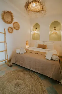 a bedroom with two beds and a ladder and mirrors at Riad Nanou - Private Riad with Pool & Rooftop in Marrakech