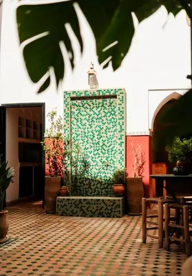 a wall with a fountain in a room with plants at Riad Nanou - Private Riad with Pool & Rooftop in Marrakech