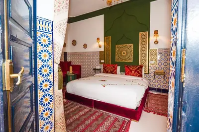 a bedroom with a bed in a room with colorful tiles at Riad Nouceiba Marrakech in Marrakech