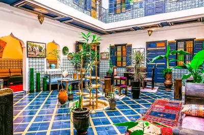 a room with plants and tables and chairs at Riad Nouceiba Marrakech in Marrakech