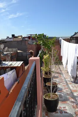 a balcony with potted plants and a clothesline with clothes at Hotel Zagora in Marrakech