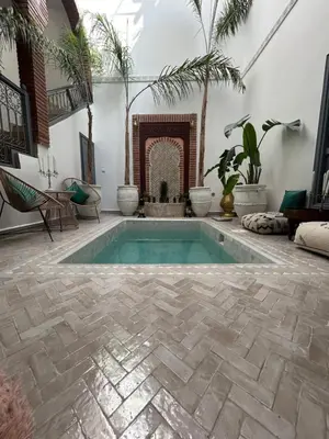 a swimming pool in a patio with a fireplace at RIAD TIFAWT in Marrakech