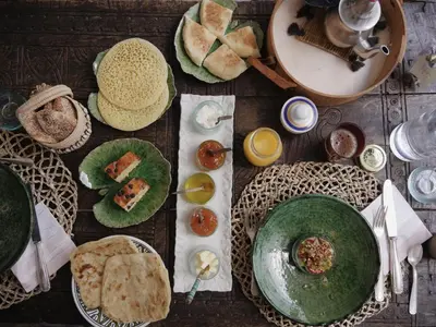 a wooden table with plates of food on it at Riad La Lumière d'Étoile in Marrakech