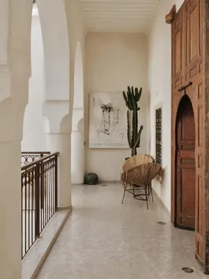a hallway with a cactus and a chair in a building at Riad La Lumière d'Étoile in Marrakech