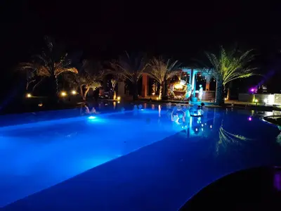 a swimming pool at night with blue lights at Domaine Alma Marrakech in Marrakech