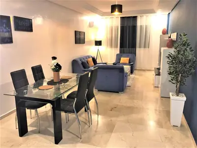 a living room with a dining table and a couch at SUPER APPART Marrakech - Confort Propreté Proximité in Marrakech
