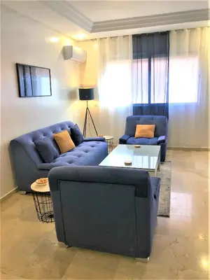a living room with two blue couches and a table at SUPER APPART Marrakech - Confort Propreté Proximité in Marrakech