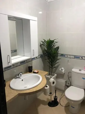 a bathroom with a sink and a toilet and a mirror at SUPER APPART Marrakech - Confort Propreté Proximité in Marrakech