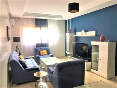 a living room with two chairs and a tv at SUPER APPART Marrakech - Confort Propreté Proximité in Marrakech
