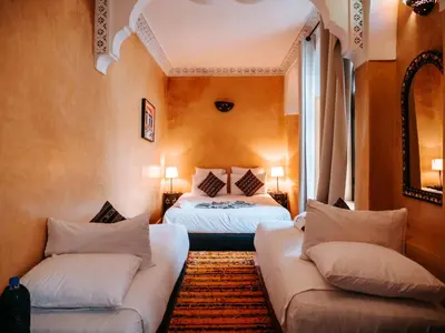 a room with two beds and two couches at Riad Amegrad in Marrakech