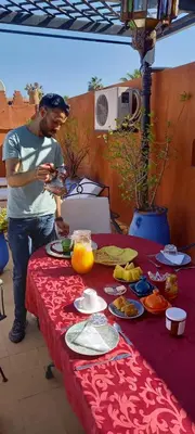 a man standing in front of a table with food at Riad Amegrad in Marrakech