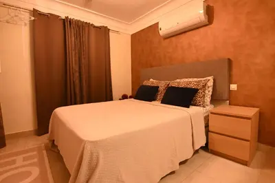 a bedroom with a bed with a white blanket and a window at Riad 5 Chambres & Piscine & Breakfast - Marrakech in Marrakech