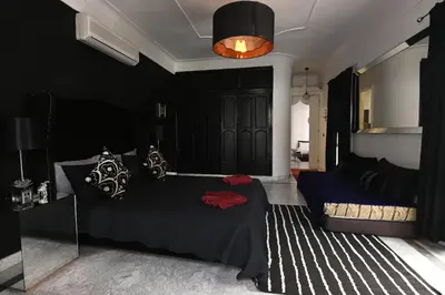 a bedroom with a bed and a black wall at Riad 5 Chambres & Piscine & Breakfast - Marrakech in Marrakech