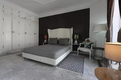 a bedroom with a bed and a black wall at Riad 5 Chambres & Piscine & Breakfast - Marrakech in Marrakech