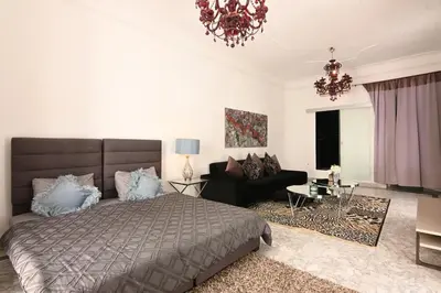 a bedroom with a bed and a living room at Riad 5 Chambres & Piscine & Breakfast - Marrakech in Marrakech