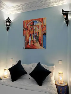 a bedroom with a bed with a painting on the wall at Dar Al Hayat in Marrakech