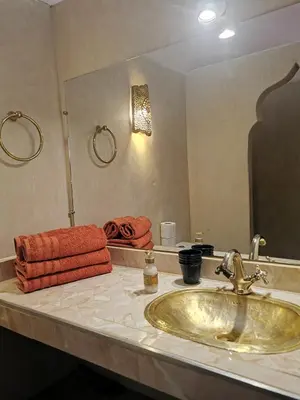 a bathroom with a sink and a large mirror at Dar Al Hayat in Marrakech