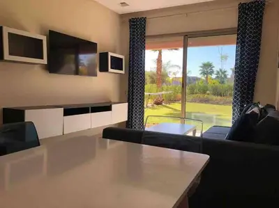 a living room with a couch and a large window at Studio sur golfe et piscine in Marrakech
