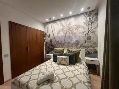 a bedroom with a bed with a large painting on the wall at Studio sur golfe et piscine in Marrakech