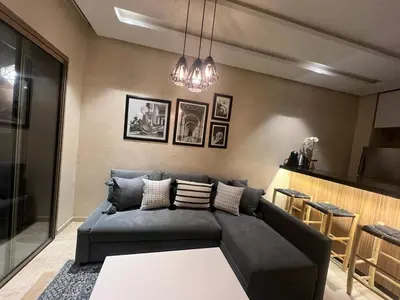 a living room with a couch and a table at Studio sur golfe et piscine in Marrakech