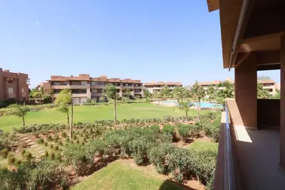 a view of the golf course from the balcony of a building at Vue sur Piscine - Prestigia détente assurée in Marrakech