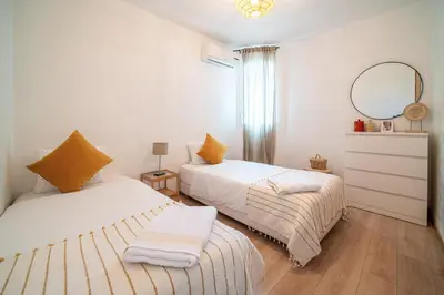 a bedroom with two beds and a mirror at Perle Rare à Bab Ighli Marrakech in Marrakech