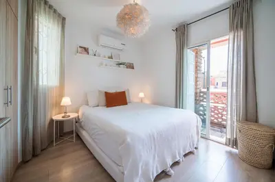 a white bedroom with a large bed and a window at Perle Rare à Bab Ighli Marrakech in Marrakech