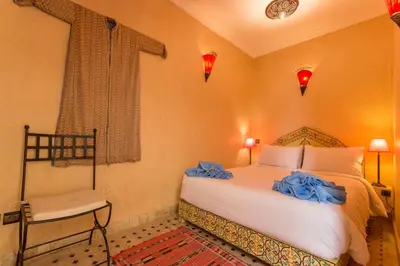 a bedroom with a bed with blue bows on it at Riad Colette EXCLUSIF - Médina - Breakfast - Wifi in Marrakech