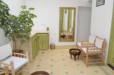 a living room with chairs and a fireplace and a mirror at Riad Dar Hamid Hotel & Spa in Marrakech
