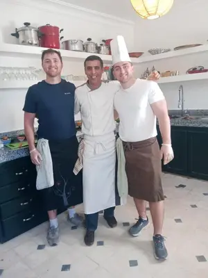 three men in a kitchen posing for a picture at Riad Dar Hamid Hotel & Spa in Marrakech