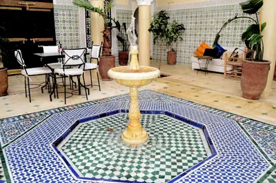 a fountain in a room with a table and chairs at Riad Dar Hamid Hotel & Spa in Marrakech