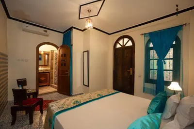 a bedroom with a bed and a room with a window at Riad De La Semaine in Marrakech