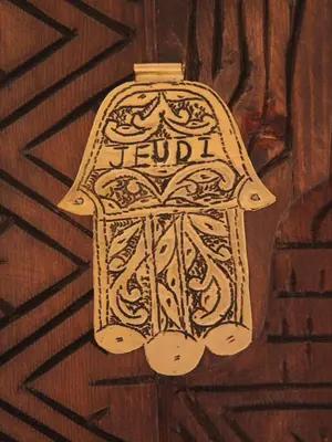 a bottle with the word fendi on a wooden door at Riad De La Semaine in Marrakech