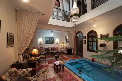 a living room with a pool in the middle of a house at Riad De La Semaine in Marrakech