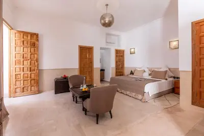 a bedroom with a bed and a table and chairs at Riad Kahena in Marrakech