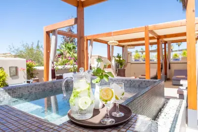 a tray with drinks on a table next to a swimming pool at Riad Kahena in Marrakech