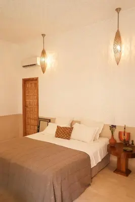 a bedroom with a bed and two pendant lights at Riad Kahena in Marrakech