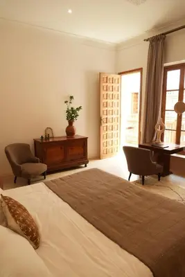 a bedroom with a bed and a desk and a piano at Riad Kahena in Marrakech