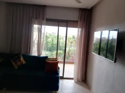 a living room with a blue couch and a large window at SUNNY 48- Appart Cozy -Marrakech-centre in Marrakech