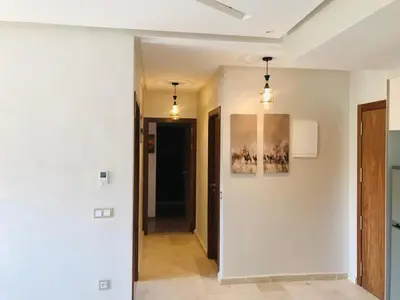 a hallway with white walls and two pendant lights at SUNNY 48- Appart Cozy -Marrakech-centre in Marrakech