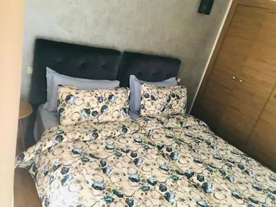 a bed with blue flowers on it in a bedroom at SUNNY 48- Appart Cozy -Marrakech-centre in Marrakech