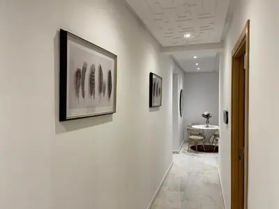 a hallway with art on the walls and a table at NEW SUPER LUXURY APARTMENT (CENTRAL MARRAKECH) in Marrakech