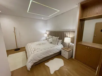 a bedroom with a bed with a light on the ceiling at NEW SUPER LUXURY APARTMENT (CENTRAL MARRAKECH) in Marrakech
