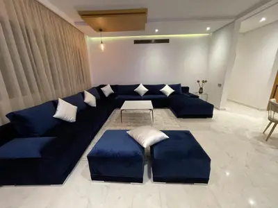 a living room with a blue couch and a table at NEW SUPER LUXURY APARTMENT (CENTRAL MARRAKECH) in Marrakech